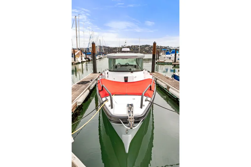 Slide: The Image of 2021 Axopar 28 Cabin boat docked in a marina, front view. - 39