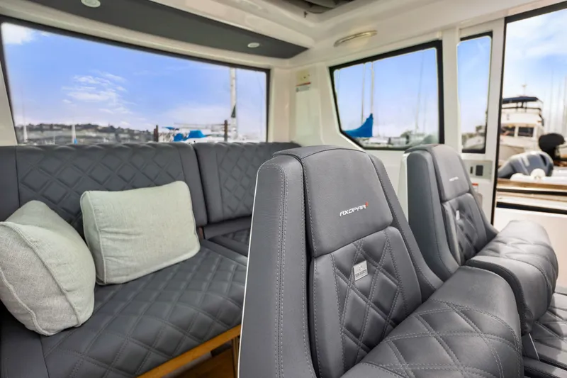 Slide: The Image of Luxurious interior of 2021 Axopar 28 Cabin with quilted seating and scenic windows. - 21