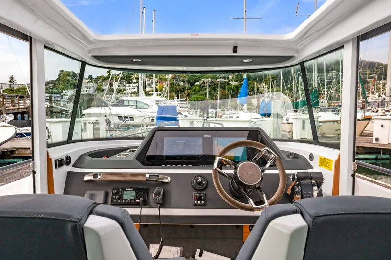 Slide: The Image of Interior view of 2021 Axopar 28 Cabin boat cockpit with steering wheel and control panel. - 34