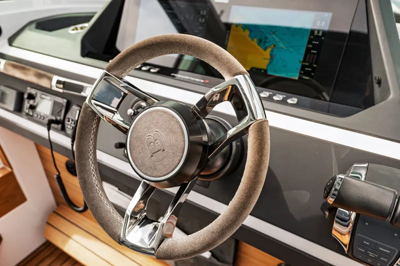 Slide: The Image of Steering wheel and dashboard of 2021 Axopar 28 Cabin boat with navigation display. - 19