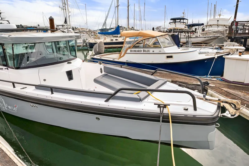 Slide: The Image of 2021 Axopar 28 Cabin boat docked in a marina with other vessels. - 38