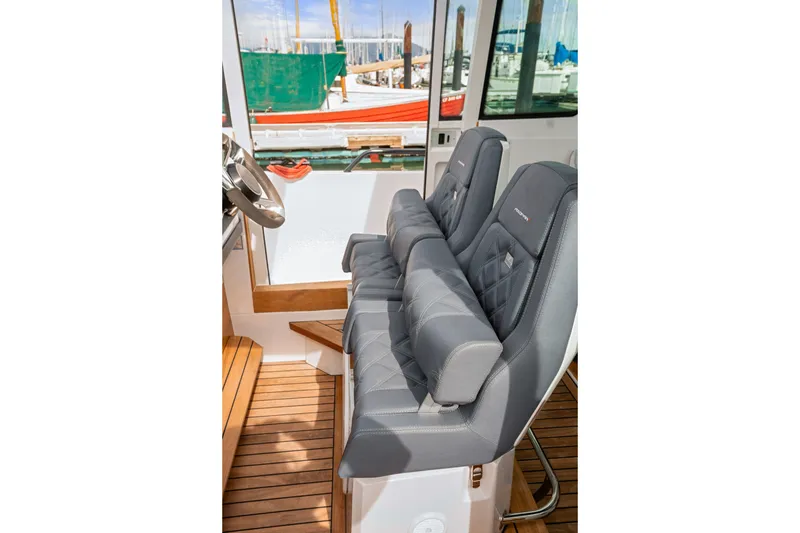 Slide: The Image of Interior of 2021 Axopar 28 Cabin with plush gray seating and wooden flooring. - 30
