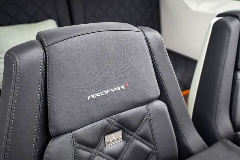 Slide: The Image of Close-up of 2021 Axopar 28 Cabin seat with logo and stitching detail. - 16