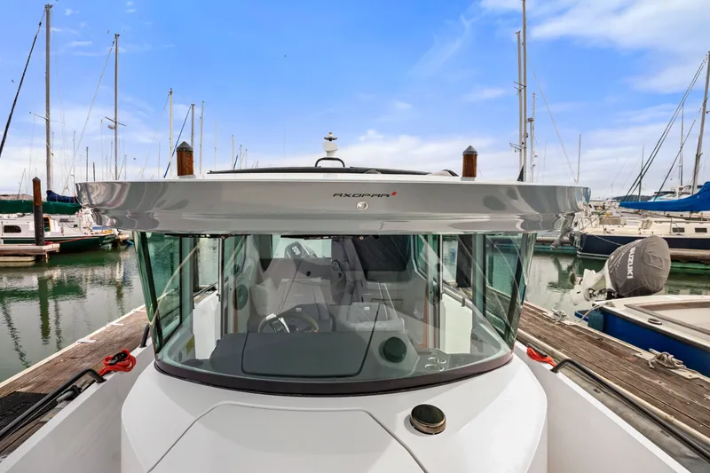 Slide: The Image of 2021 Axopar 28 Cabin boat docked in a marina with sailboats. - 35
