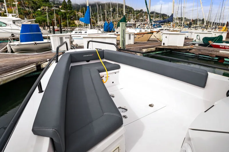 Slide: The Image of 2021 Axopar 28 Cabin boat with sleek seating, docked in a marina. - 36