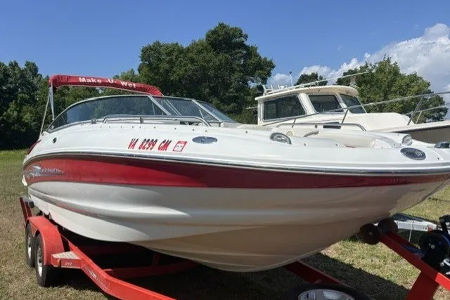 Slide: The Image of 2004 Crownline 240 EX boat on trailer, red and white design, parked outdoors. - 2