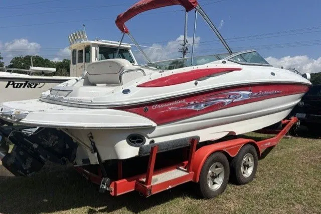 Slide: The Image of 2004 Crownline 240 EX boat on red trailer, parked outdoors under clear sky. - 3