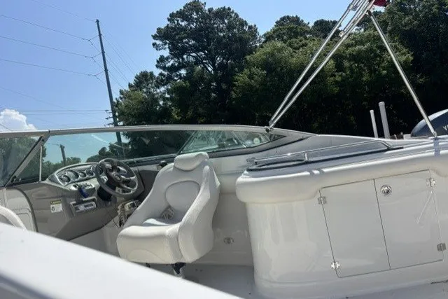 Slide: The Image of 2004 Crownline 240 EX boat interior with white seating and steering wheel. - 5