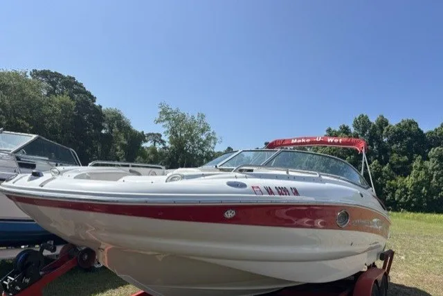 Slide: The Image of 2004 Crownline 240 EX boat on trailer, parked outdoors under clear sky. - 4