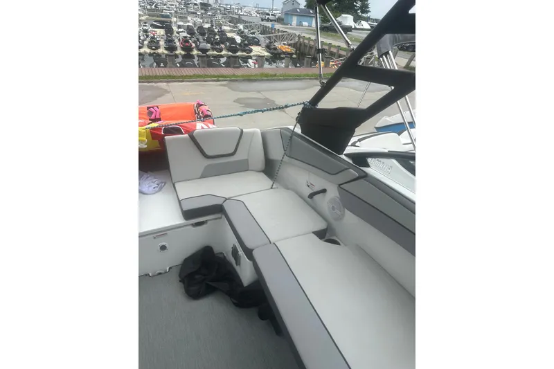 Slide: The Image of 2025 Yamaha Boats AR220 interior seating with modern design and waterfront view. - 13
