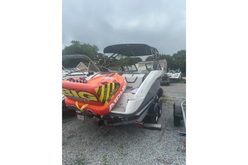 Slide: The Image of 2025 Yamaha Boats AR220 with inflatable tube, parked on gravel lot. - 5