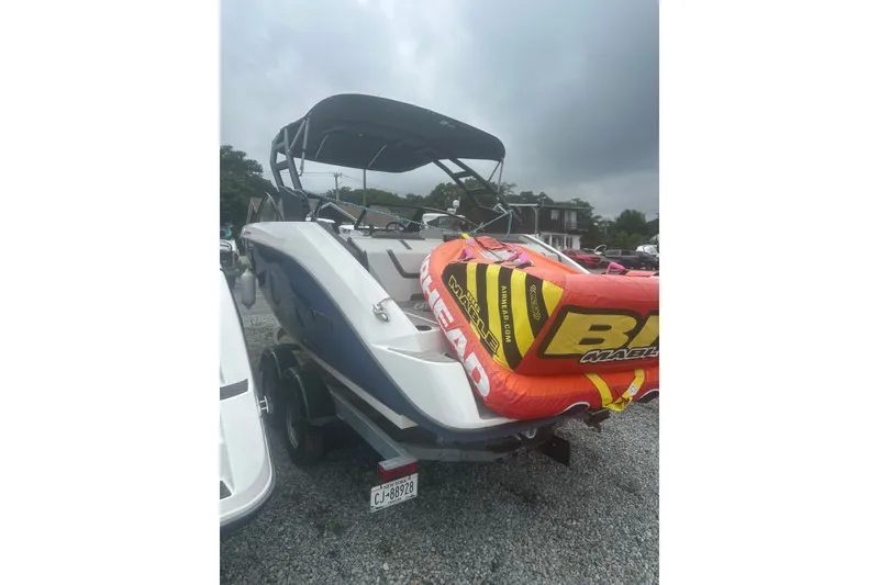 Slide: The Image of 2025 Yamaha Boats AR220 with inflatable tube on trailer, parked outdoors. - 4