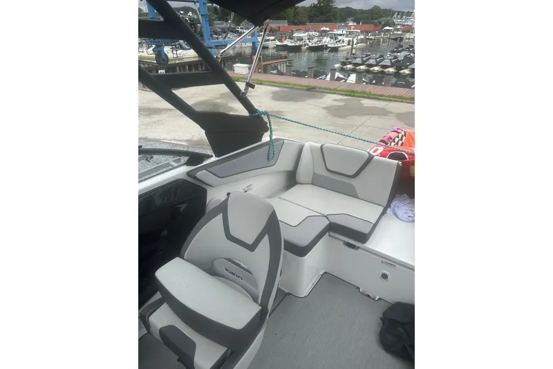 Slide: The Image of 2025 Yamaha Boats AR220 interior with sleek seating at a marina backdrop. - 10