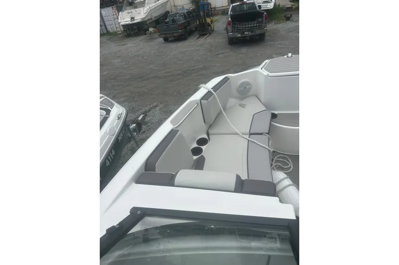 Slide: The Image of 2025 Yamaha Boats AR220 interior with gray seating and cup holders. - 14