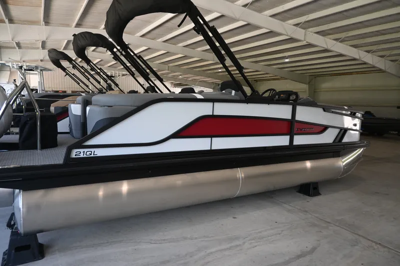 Slide: The Image of A 2027 Evotti 521QL pontoon boat in a warehouse, featuring black and red accents. - 2