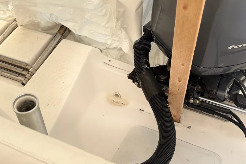 Slide: The Image of 2014 Sea Fox 226 Commander boat engine area with visible hose and support beam. - 18