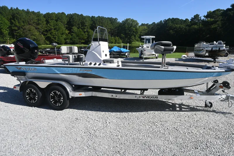 The Image of A 2027 Vexus ACX2000 boat on a trailer, surrounded by trees and other boats. - 1
