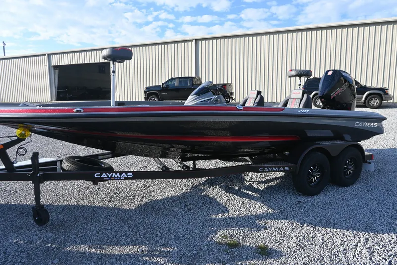 Slide: The Image of A 2027 Caymas 201 Pro boat on a trailer in a gravel lot. - 4