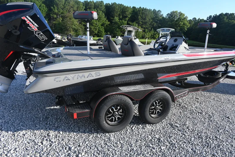 Slide: The Image of A 2027 Caymas 201 Pro boat on a trailer in a gravel lot. - 2
