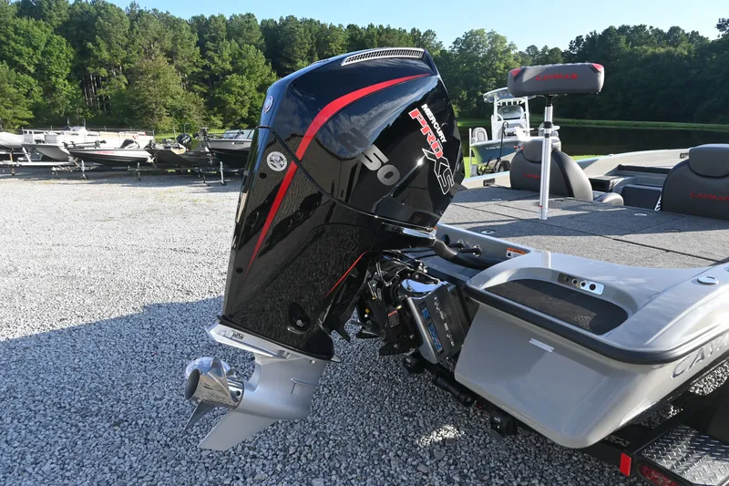 Slide: The Image of A Caymas 201 Pro boat with a powerful outboard motor, parked on a gravel lot. - 3