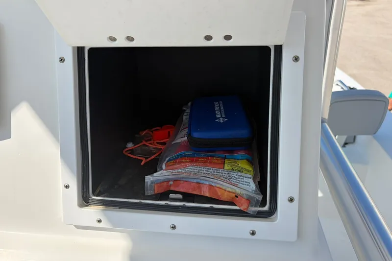 Slide: The Image of Storage compartment on a 2021 KenCraft BAYRIDER 2260FS boat with safety gear inside. - 21