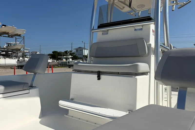 Slide: The Image of 2021 KenCraft BAYRIDER 2260FS boat interior with seating and console, docked under clear sky. - 13