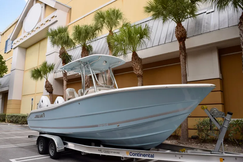The Image of 2027 Bulls Bay 255 Center Console boat on trailer, parked near palm trees. - 0