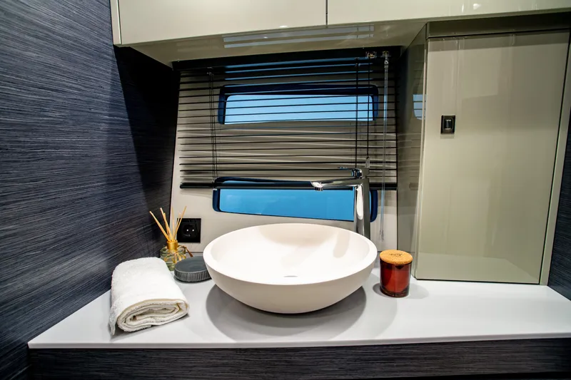Slide: The Image of Modern bathroom interior on 2025 Cobrey 45 FLY yacht, featuring sleek sink and window view. - 14
