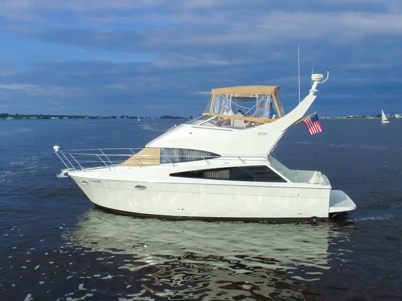 Slide: The Image of A white 2006 Carver 33 Super Sport yacht on calm water with an American flag. - 1