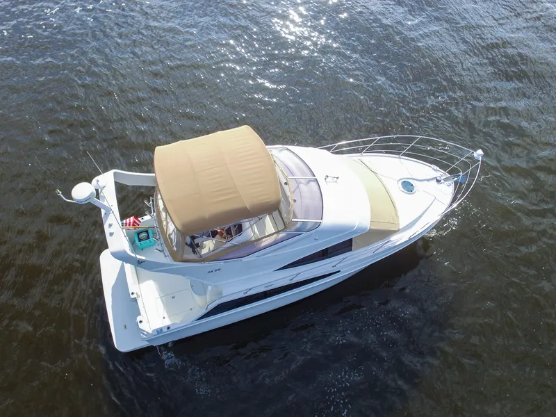 Slide: The Image of A 2006 Carver 33 Super Sport on the water with a beige sunshade. - 11