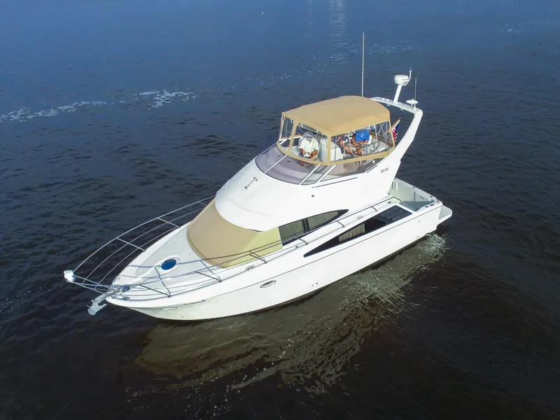 Slide: The Image of De Carver 33 Super Sport uit 2006 vaart op kalm water, met een beige luifel en ruim dek. - 8