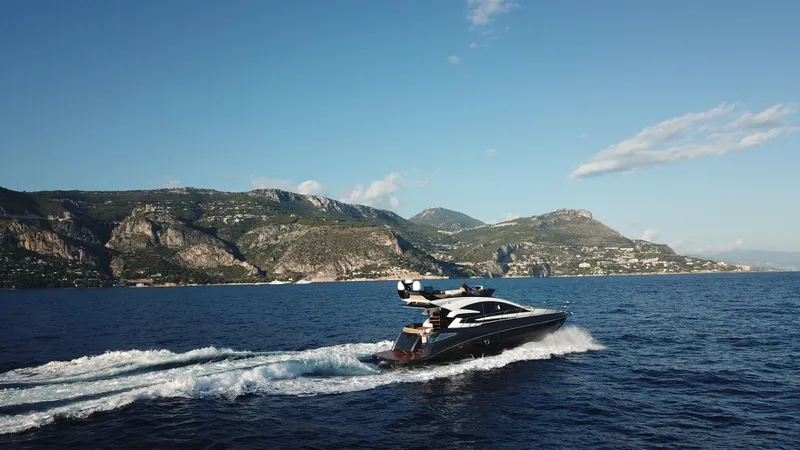 Slide: The Image of 2025 Cobrey 52 FLY yacht cruising on scenic coastal waters. - 6