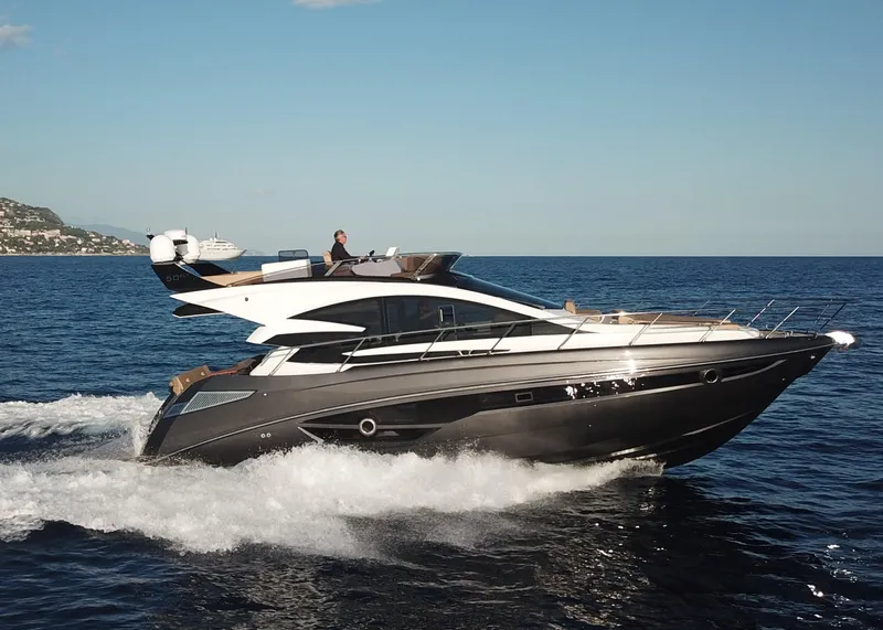 Slide: The Image of 2025 Cobrey 52 FLY yacht cruising on open sea under clear blue sky. - 1