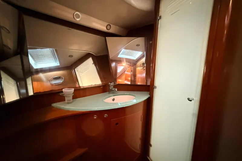 Slide: The Image of Luxurious bathroom interior of a 2005 Beneteau 57 yacht, featuring elegant wood finishes. - 27