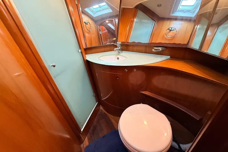 Slide: The Image of Luxurious bathroom in a 2005 Beneteau 57 yacht with wooden cabinetry and modern fixtures. - 23