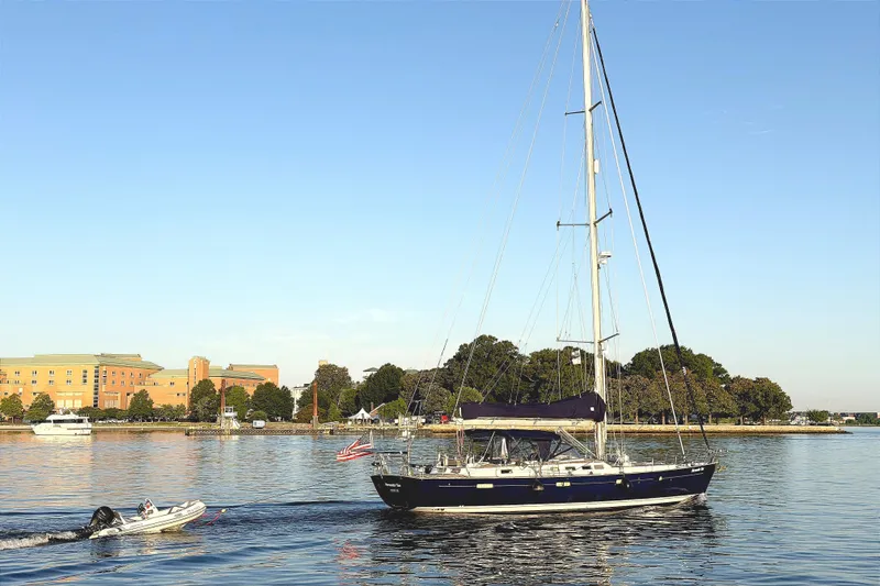 The Image of Eine Beneteau 57 von 2005 segelt in ruhigem Wasser, mit einem Beiboot im Schlepptau. - 0