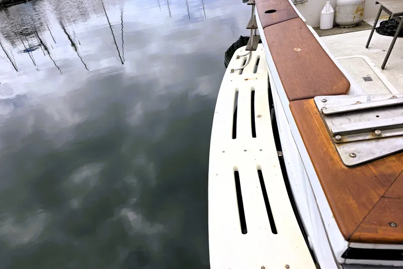 Slide: The Image of 1984 Californian 43 Motoryacht deck with wooden accents, reflecting on calm water. - 28