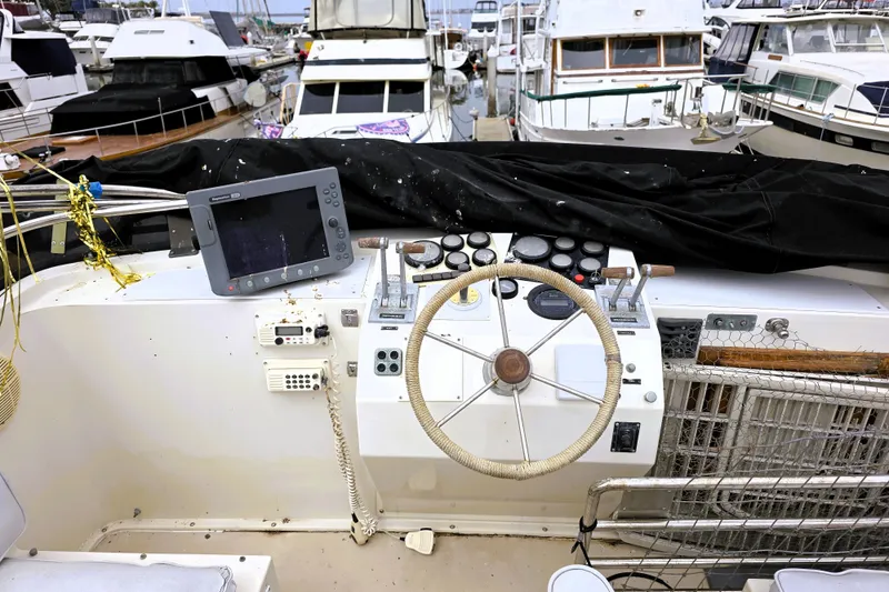 Slide: The Image of 1984 Californian 43 Motoryacht helm with steering wheel and navigation equipment in marina. - 32