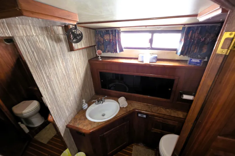 Slide: The Image of 1984 Californian 43 Motoryacht bathroom with sink, mirror, and wooden cabinetry. - 18