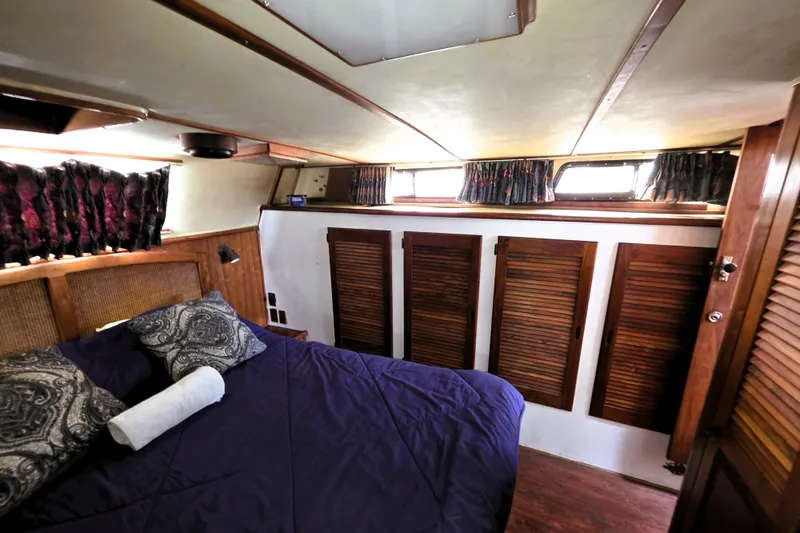 Slide: The Image of Cozy bedroom interior of 1984 Californian 43 Motoryacht with wood accents and plush bedding. - 16