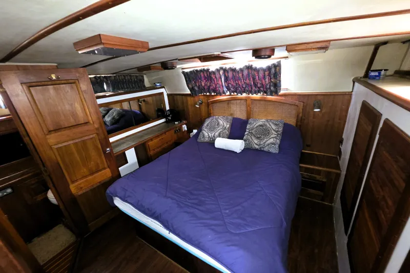 Slide: The Image of Cozy bedroom interior of 1984 Californian 43 Motoryacht with wooden accents and blue bedding. - 15