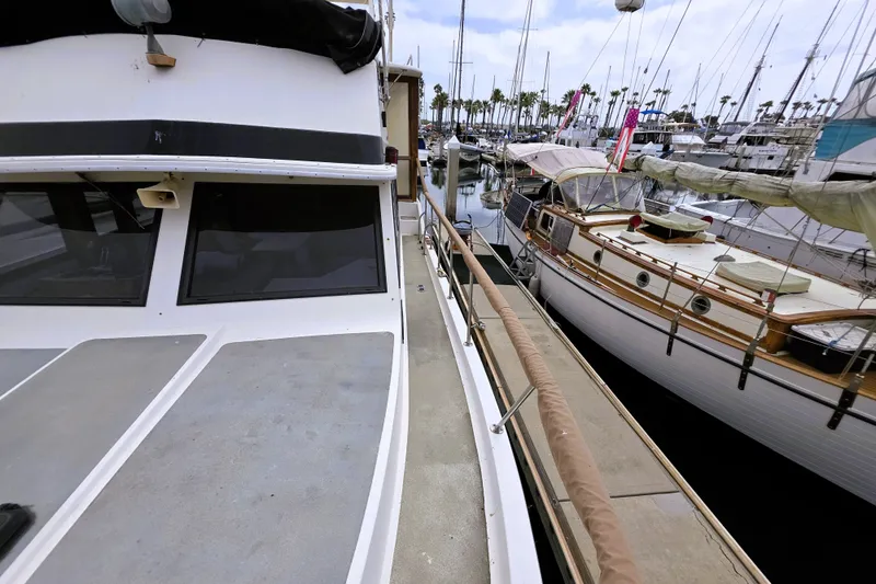 Slide: The Image of 1984 Californian 43 Motoryacht docked at marina, surrounded by sailboats. - 24
