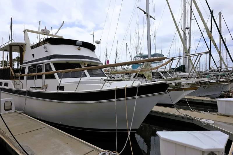Slide: The Image of 1984 Californian 43 Motoryacht docked at marina, surrounded by sailboats. - 26