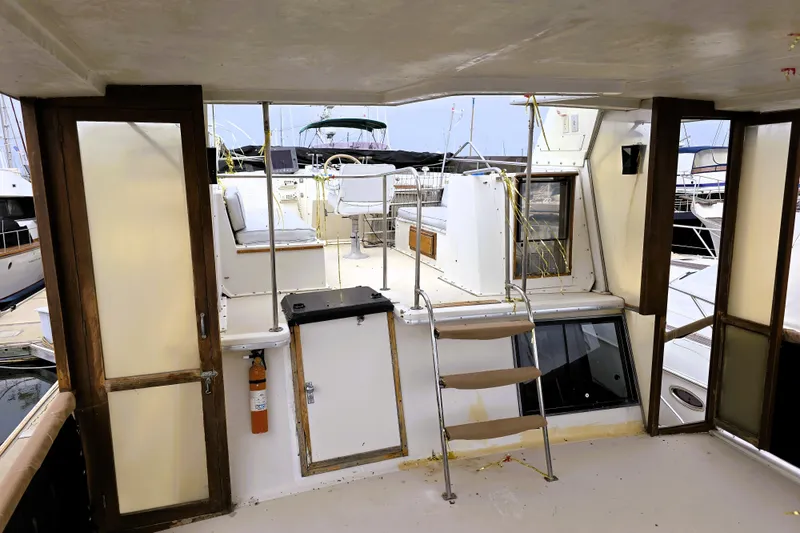 Slide: The Image of 1984 Californian 43 Motoryacht interior with seating and ladder, docked at marina. - 30
