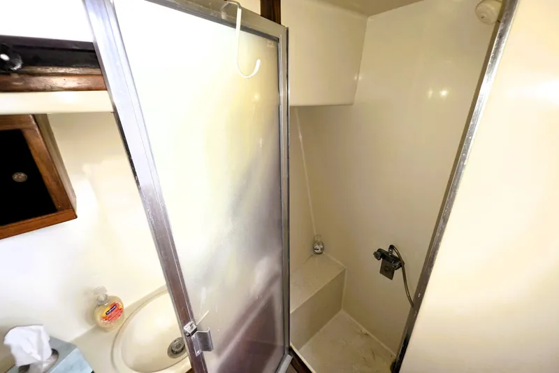 Slide: The Image of 1984 Californian 43 Motoryacht bathroom with shower, sink, and frosted glass door. - 13