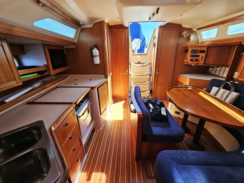 Slide: The Image of Interior of a 1999 Catalina 42 MkII with wooden cabinetry and blue upholstery. - 33