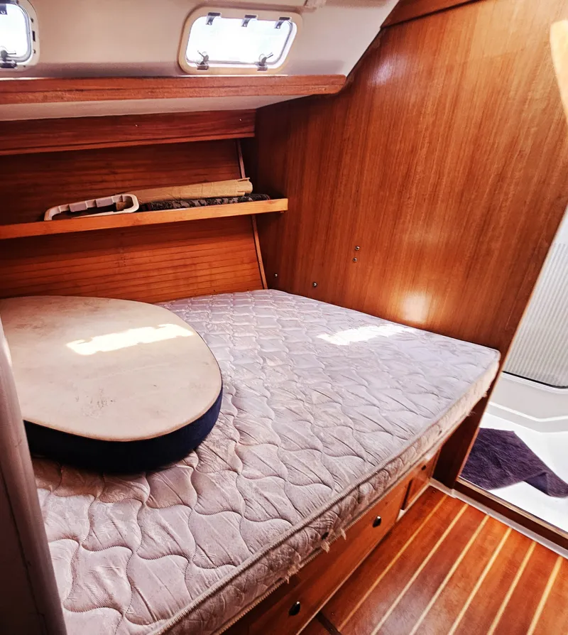 Slide: The Image of The cabin of a 1999 Catalina 42 MkII features a cozy bed and wood paneling. - 20