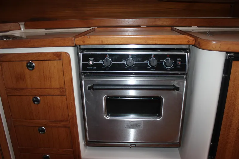 Slide: The Image of Built-in oven in a boat galley with wooden cabinets and stainless steel surface. - 27