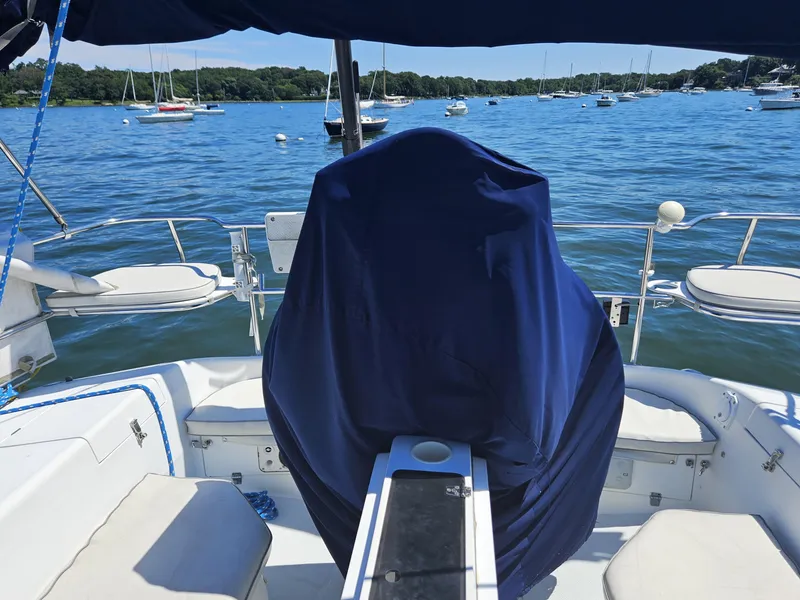 Slide: The Image of The cockpit of a 1999 Catalina 42 MkII with a blue cover, overlooking the water. - 14