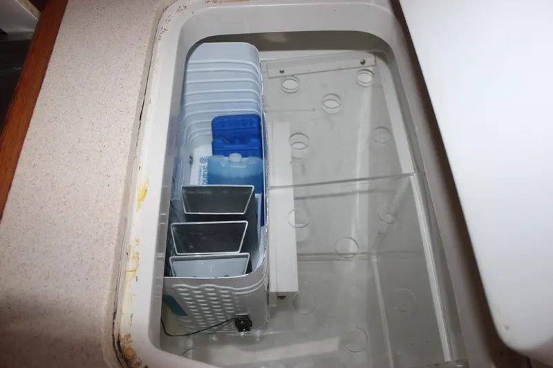 Slide: The Image of An open storage compartment with plastic containers and trays inside. - 31